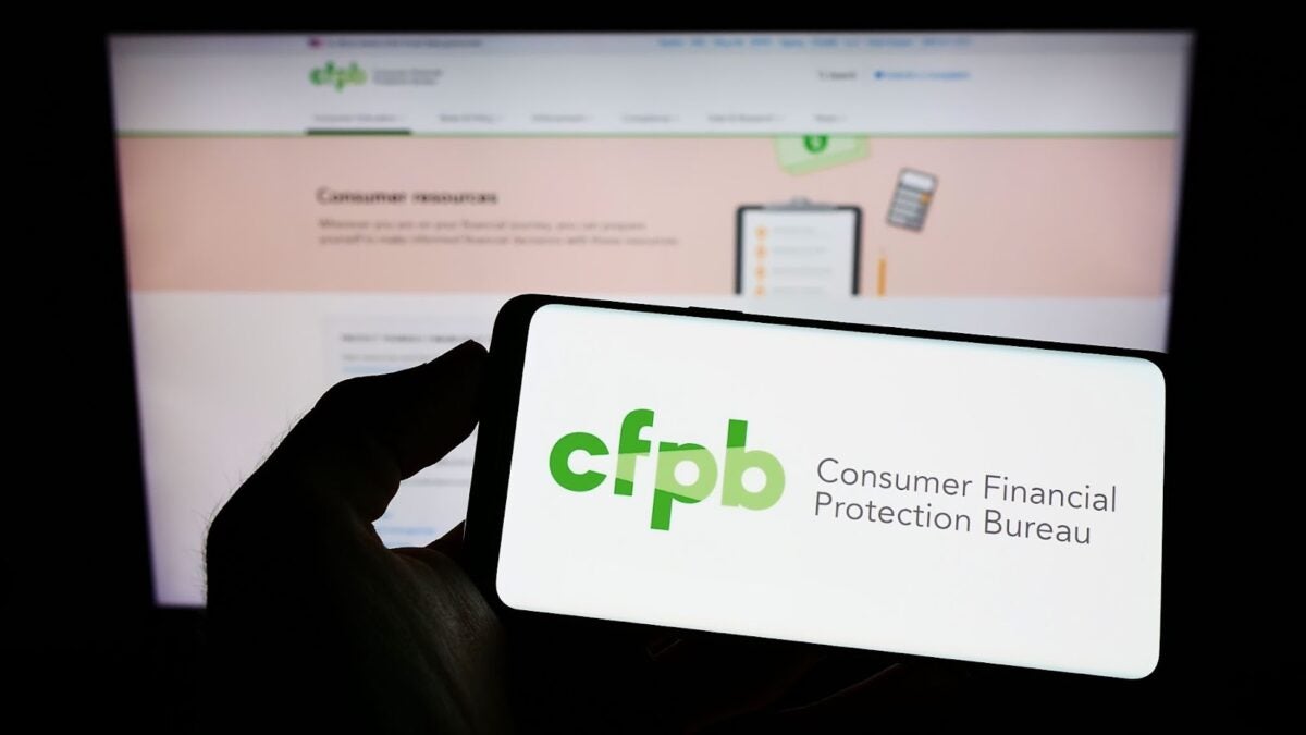 Hand holding a phone that is accessing the Consumer Financial Protection Bureau.