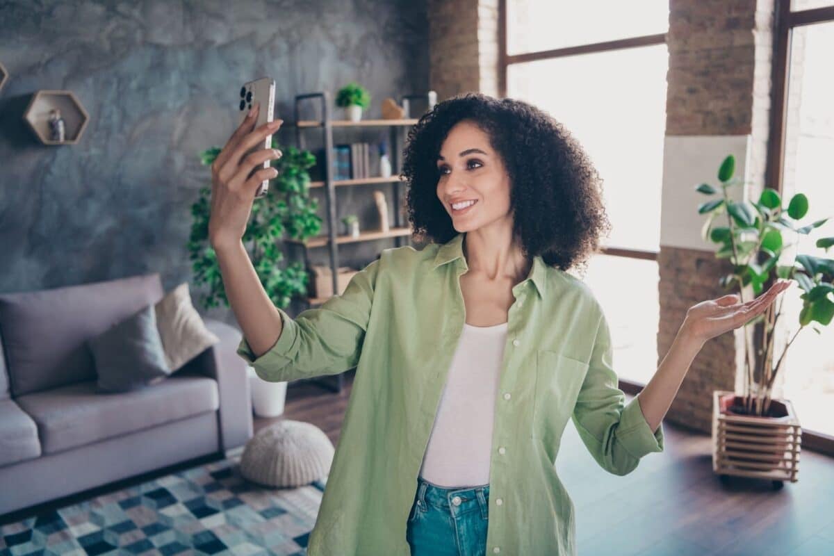 A woman holding her phone to take a selfie.