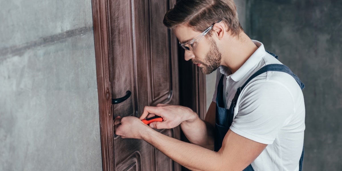 A man trying to pick a door lock