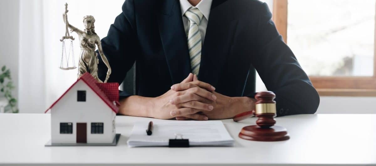 Close-up photo of judge Wooden hammer and small wooden house on the table.