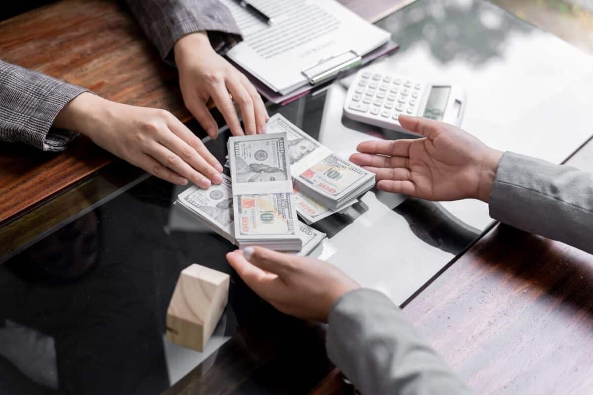 Hands passing money across a table. 