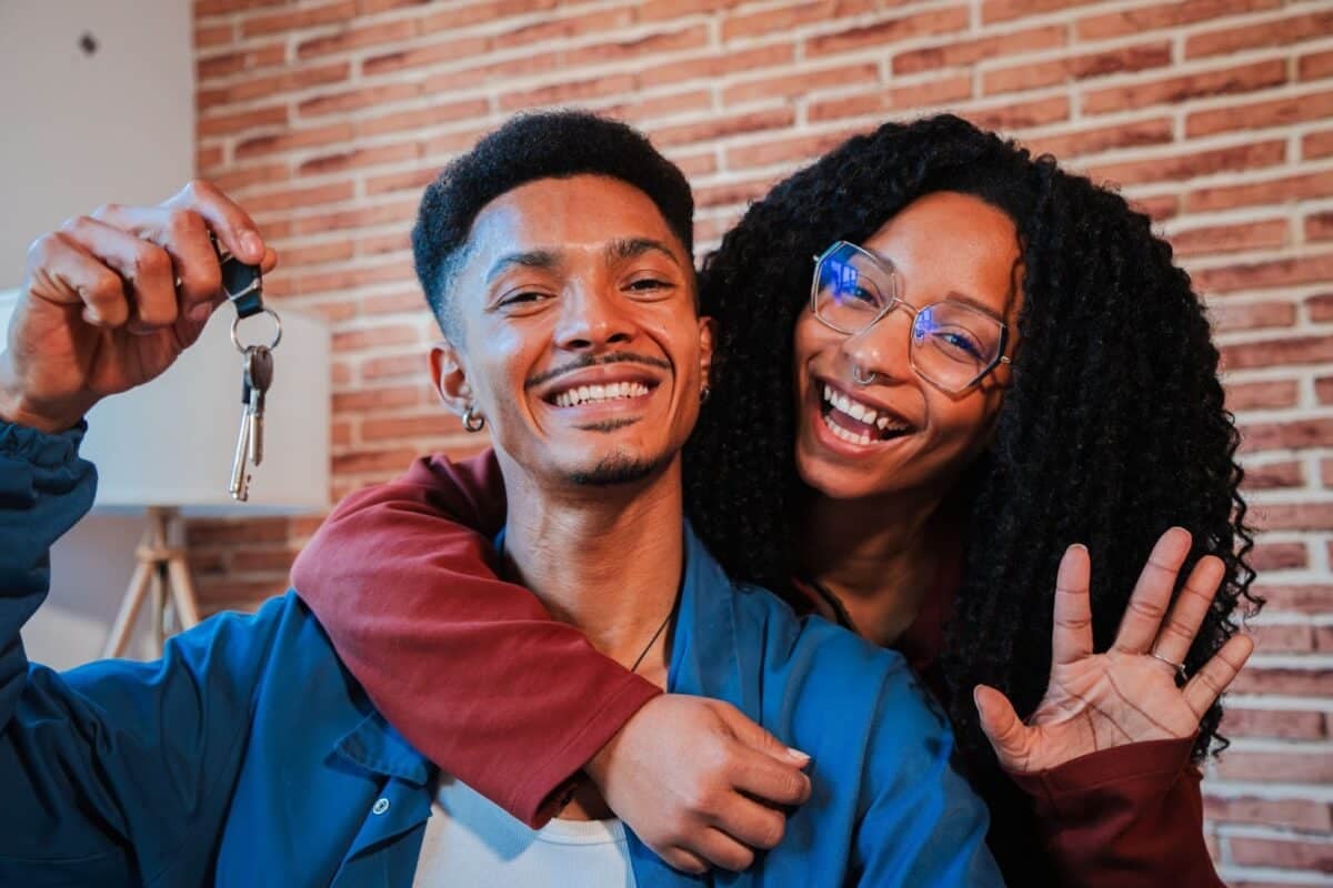 Young couple holding keys to their first home.