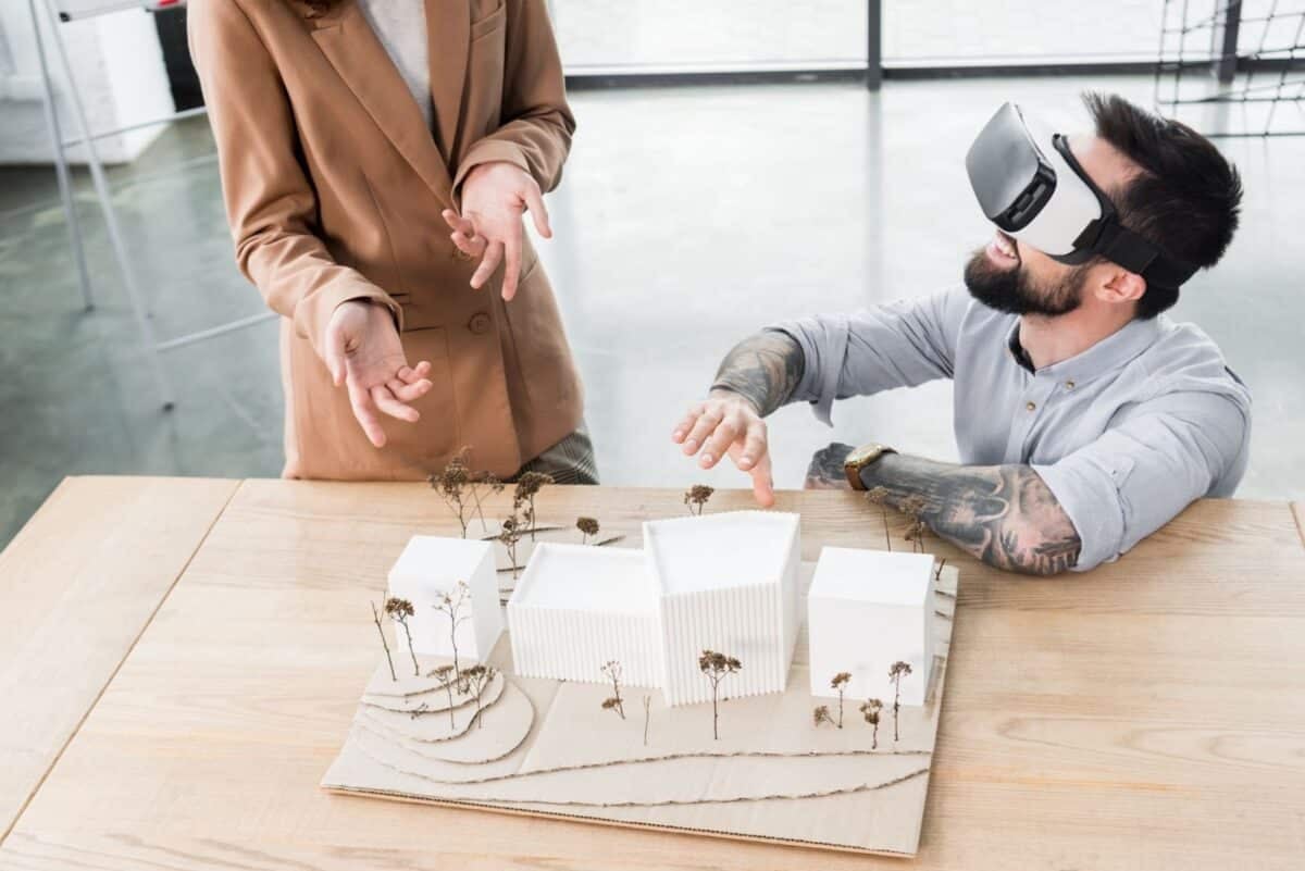 Virtual reality architect in virtual reality headset talking with colleague.