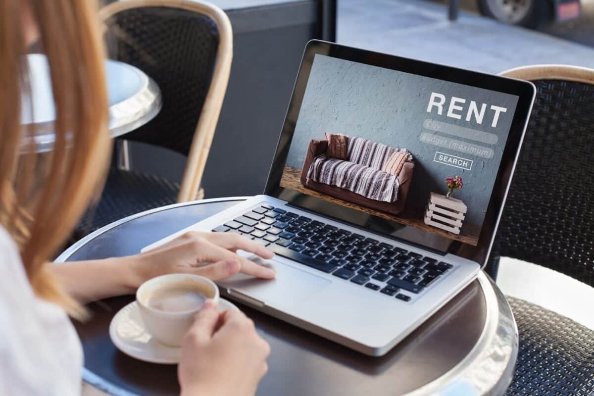  A person at a coffee shop looking at rentals on a computer.