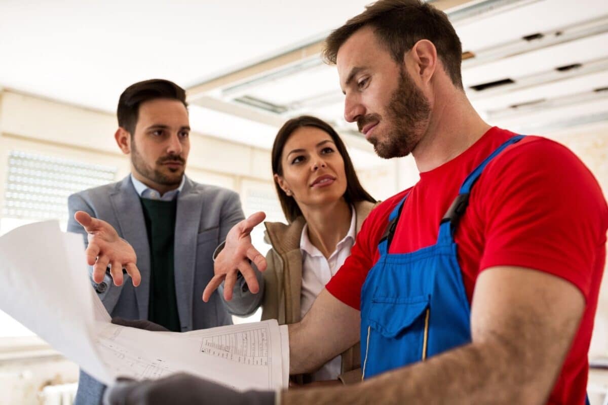 Young couple shows to builder handyman problem about renovations their home.