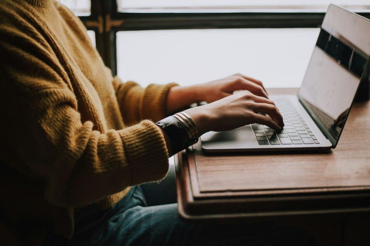 Person sitting in front of a laptop while typing