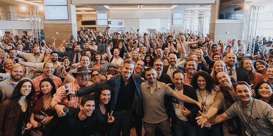 A huge group of real estate agents behind well-known agent Ryan Serhant in modern downtown office