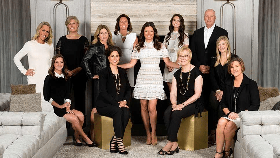 A team of real estate Agents posing for a group photograph in a luxury office setting