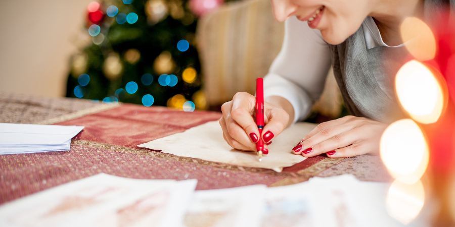 a lady holding a red pen writing in the paper