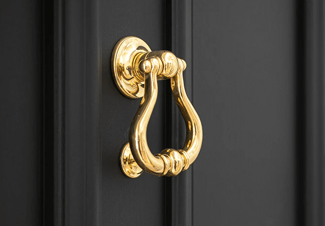 A gold-colored door knocker